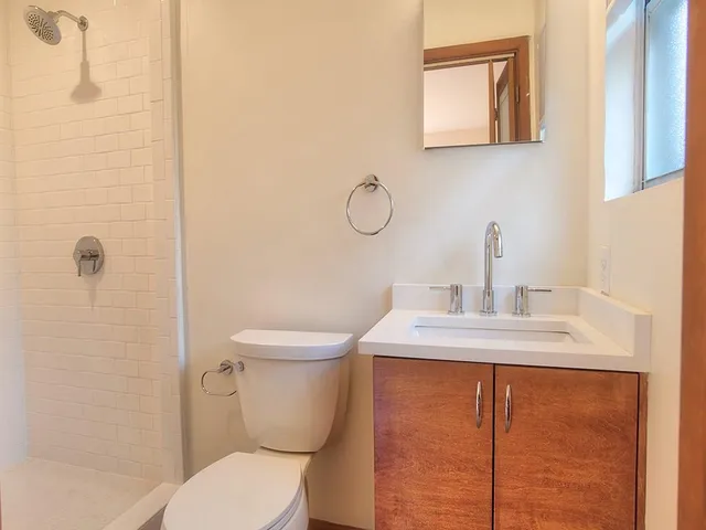 a bathroom with a toilet sink and mirror