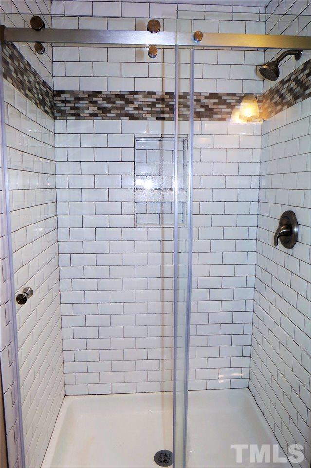 5224 Olive Road Raleigh, NC 27606 - Photo 10 of 19 Renovated bathroom with new tile shower, glass sliding shower door and vanity.