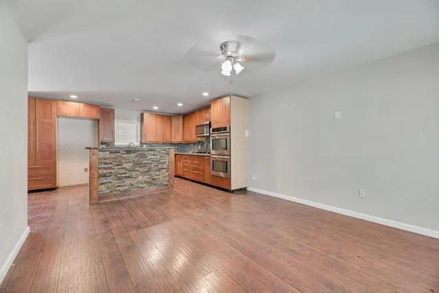 a view of a kitchen with a sink cabinet an oven and refrigerator