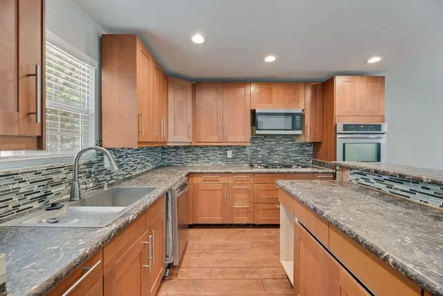 a kitchen with granite countertop a sink and a stove
