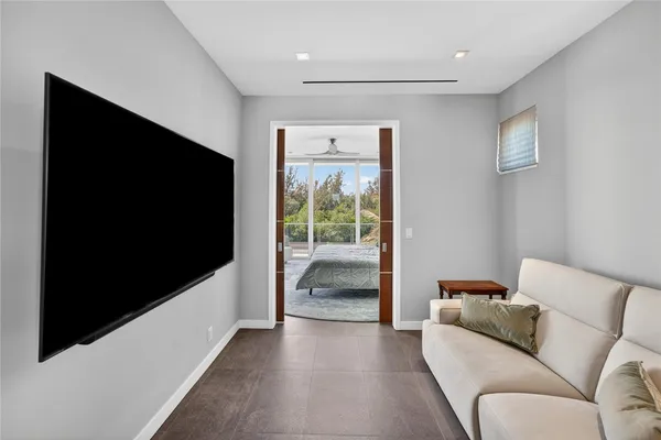 a bedroom with bed a painting on the wall and a window