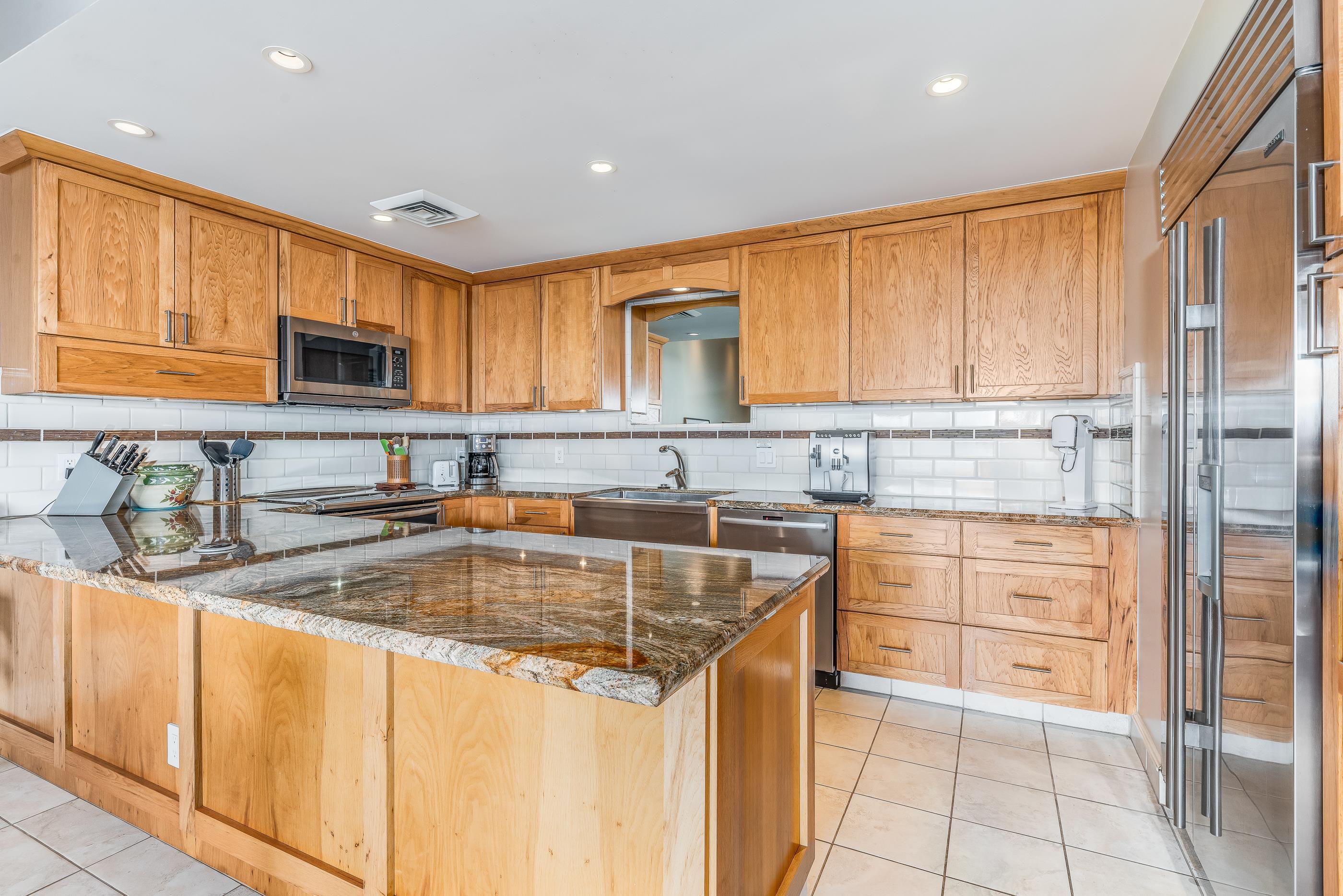 4850 Makena Alanui Road, Unit C106 Kihei, HI 96753 - Photo 15 of 49 a kitchen with granite countertop a sink stove and cabinets