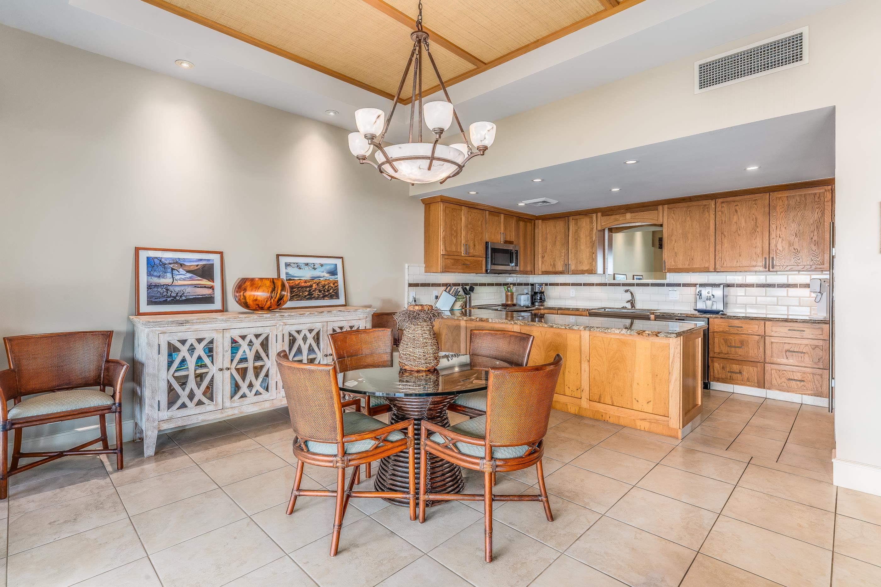 4850 Makena Alanui Road, Unit C106 Kihei, HI 96753 - Photo 19 of 49 a dining area with stainless steel appliances granite countertop a stove top oven a kitchen island a dining table and chairs