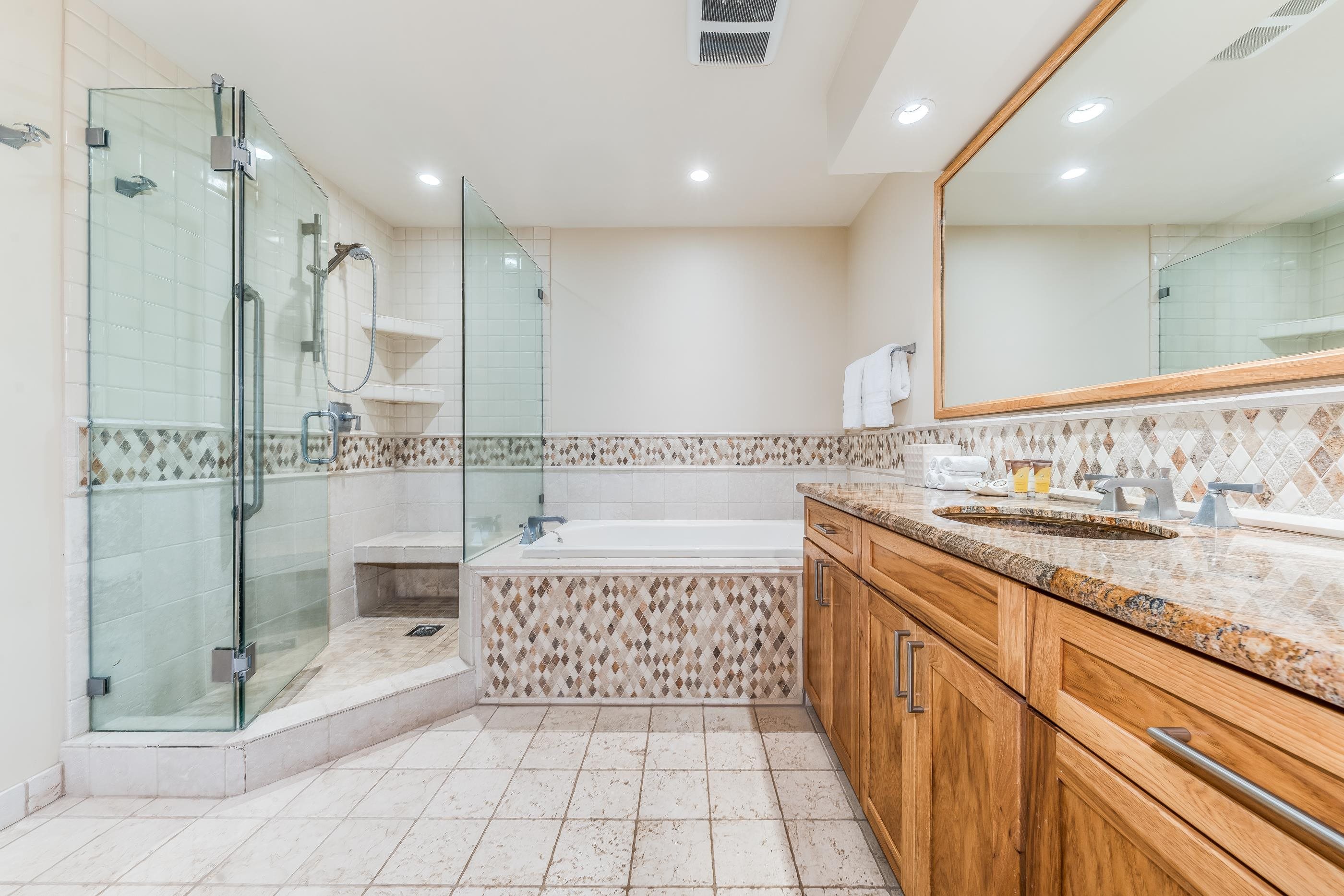4850 Makena Alanui Road, Unit C106 Kihei, HI 96753 - Photo 22 of 49 a bathroom with a granite countertop sink a toilet a mirror and shower