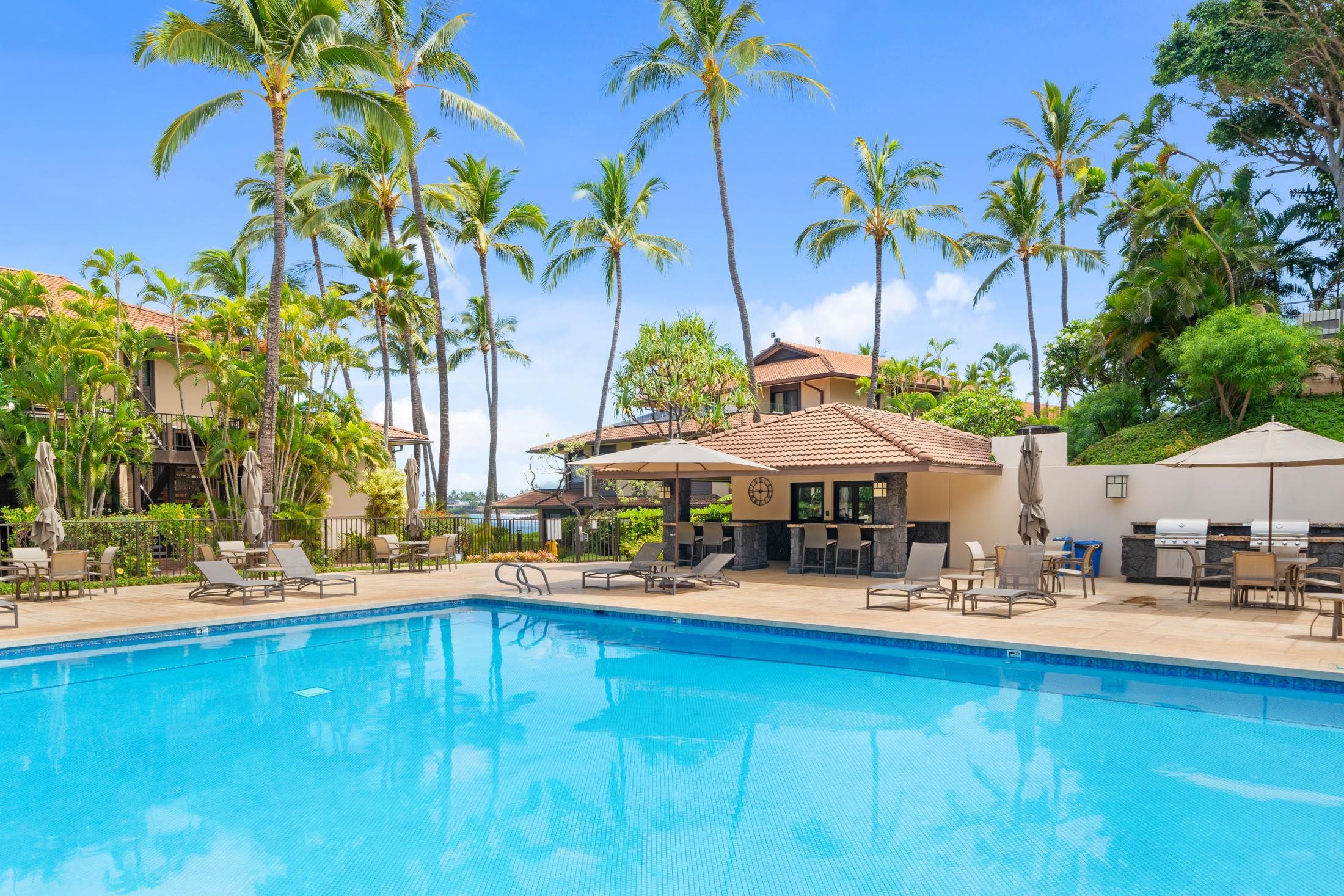 4850 Makena Alanui Road, Unit C106 Kihei, HI 96753 - Photo 31 of 49 a backyard of a house with table and chairs under an umbrella