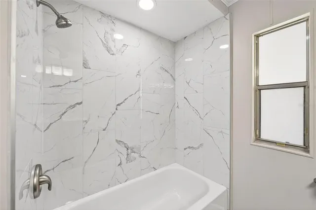 an empty room with wooden floor and a ceiling fan