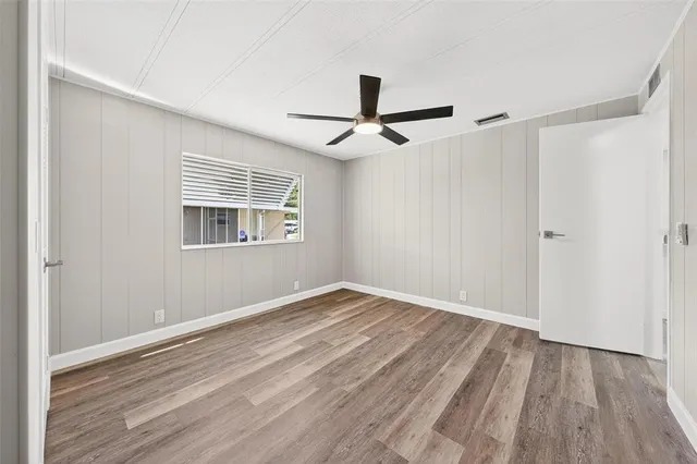 a view of hallway with wooden floor and a ceiling fan