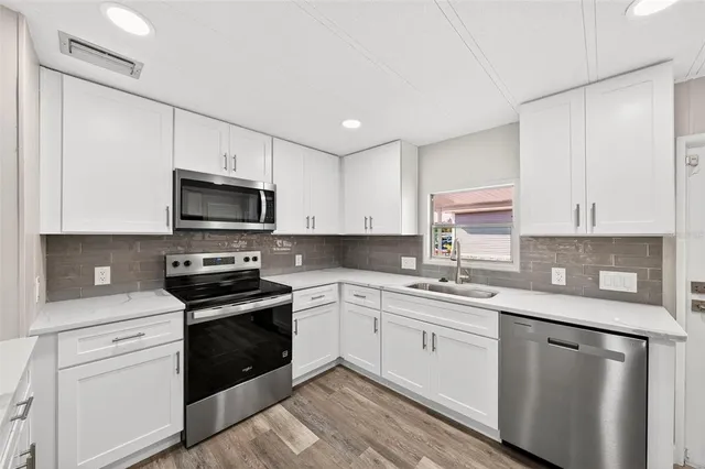 a kitchen with a sink white cabinets and white appliances