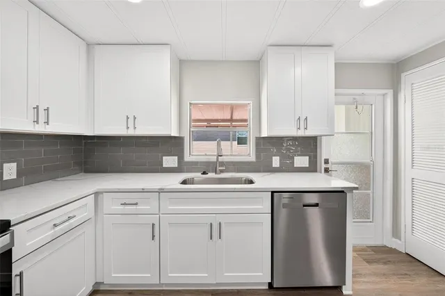 a kitchen with white cabinets and white appliances