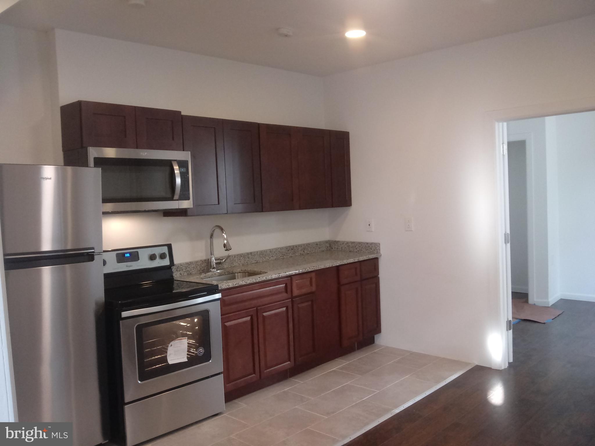 a kitchen with stainless steel appliances a stove a microwave and a sink