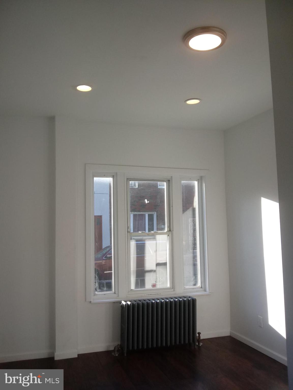 1145 South 23rd Street, Unit 1 Philadelphia, PA 19146 - Photo 11 of 12 an empty room with wooden floor and windows