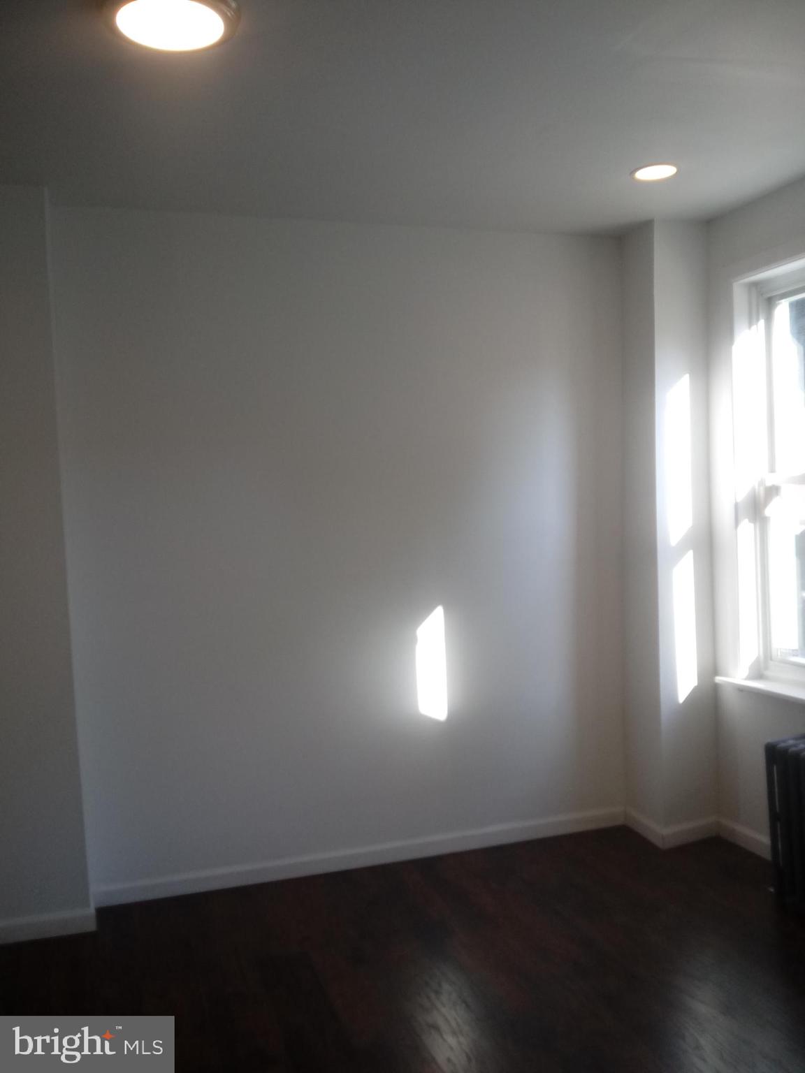 1145 South 23rd Street, Unit 1 Philadelphia, PA 19146 - Photo 10 of 12 an empty room with wooden floor and windows