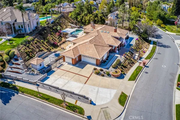 an aerial view of a house with a garden and outdoor seating