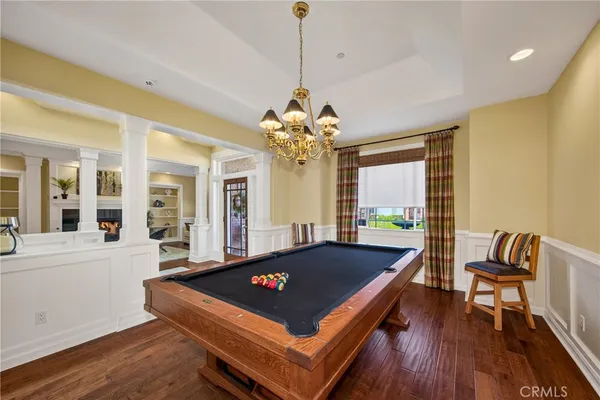 a living room with pool table and a chandelier