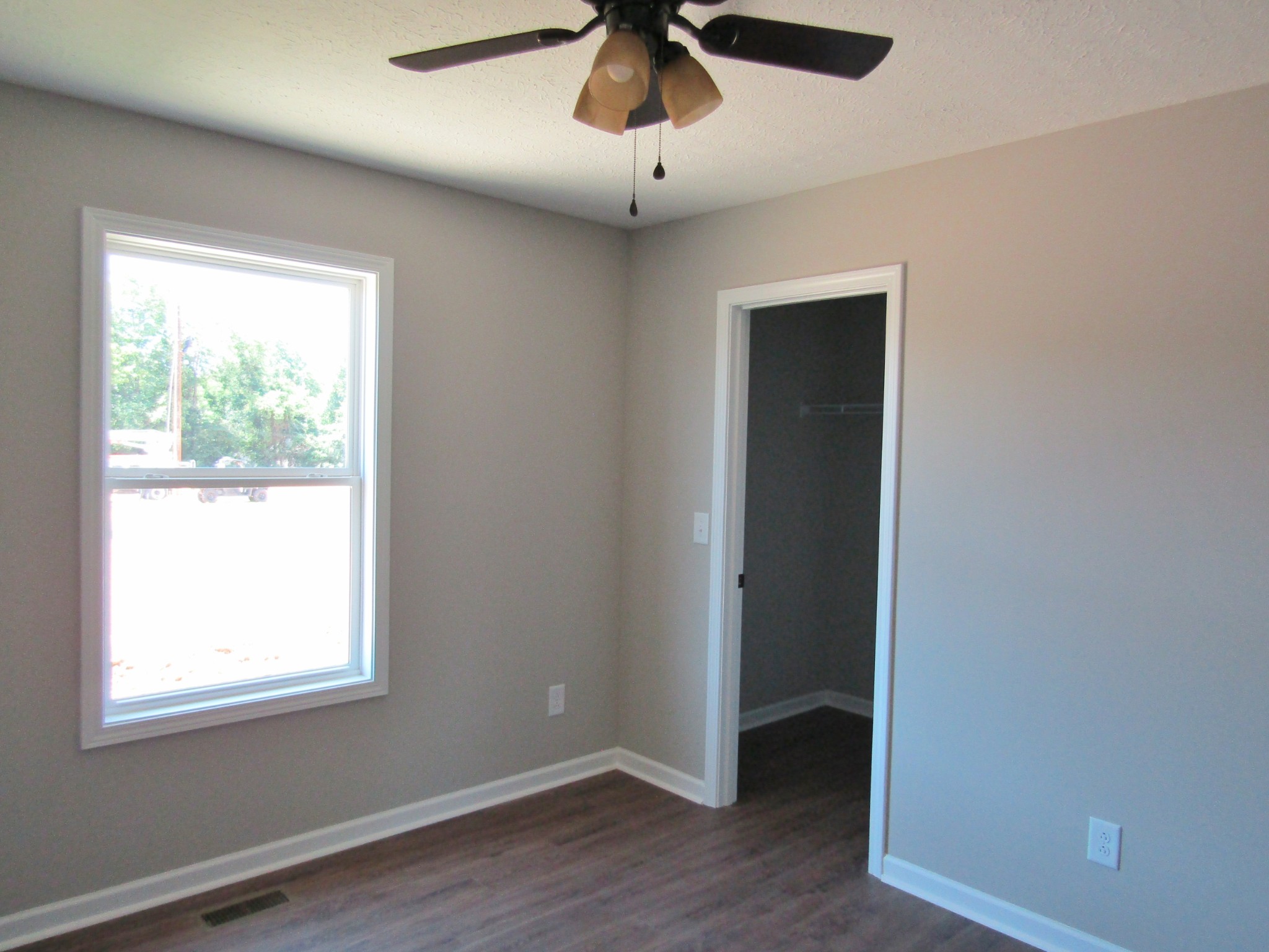 470 Crescent Factory Road Lawrenceburg, TN 38464 - Photo 12 of 15 an empty room with wooden floor chandelier fan and windows