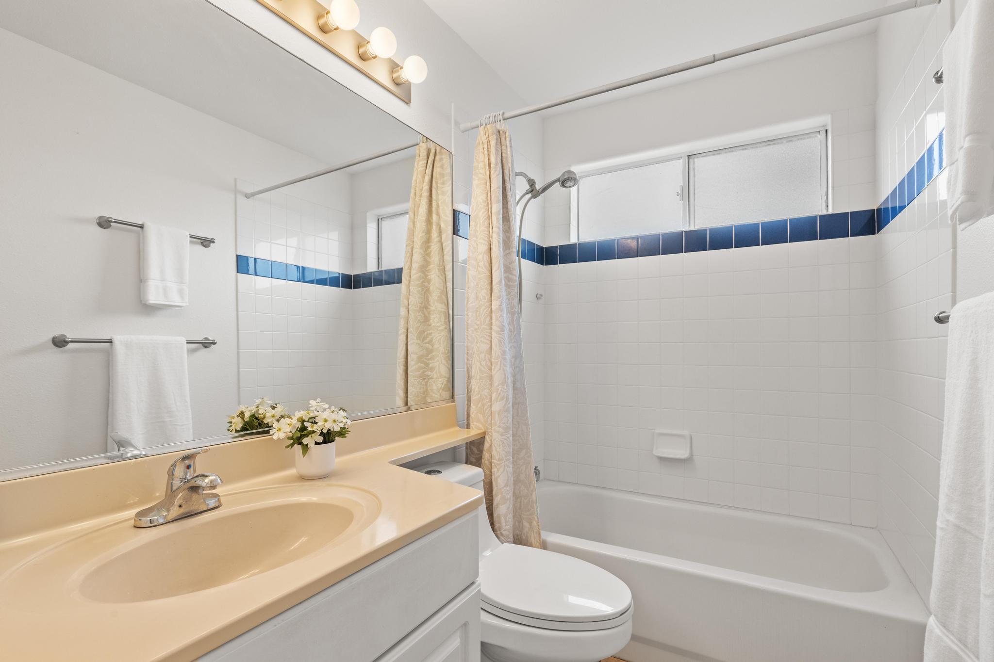 75-6081 Alii Drive, Unit V106 Kailua-Kona, HI 96740 - Photo 11 of 25 a bathroom with a sink and a mirror