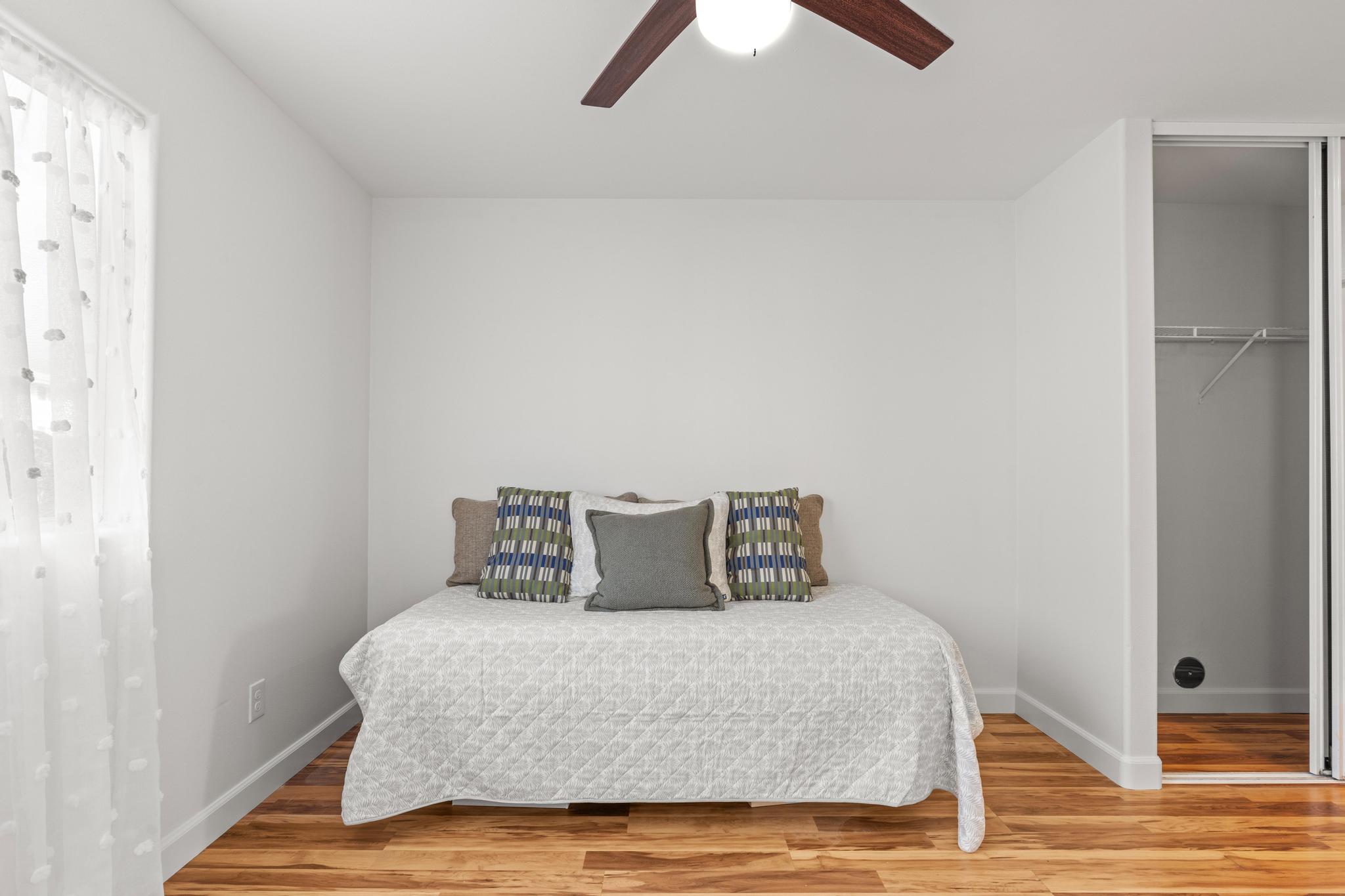 75-6081 Alii Drive, Unit V106 Kailua-Kona, HI 96740 - Photo 14 of 25 a bedroom with a bed and wooden floor