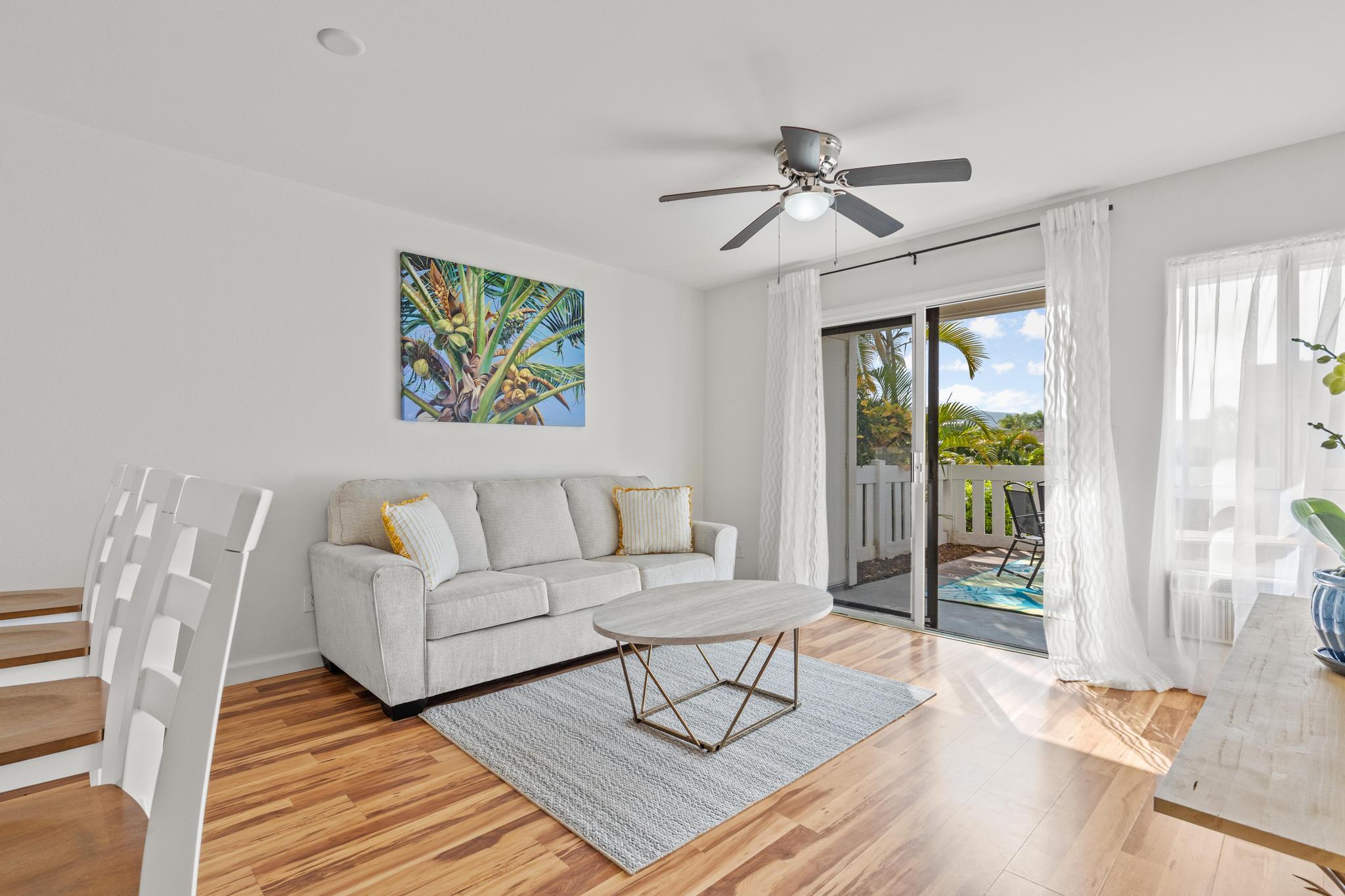 75-6081 Alii Drive, Unit V106 Kailua-Kona, HI 96740 - Photo 2 of 25 a living room with furniture a large window and wooden floor