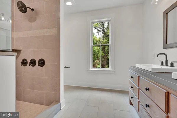 a bathroom with a tub sink and mirror