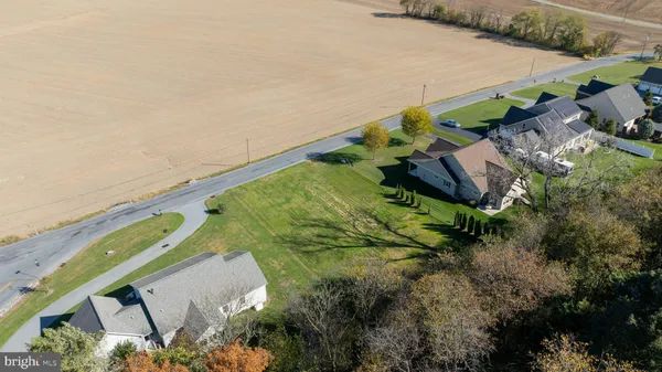 an aerial view of residential houses with outdoor space and trees