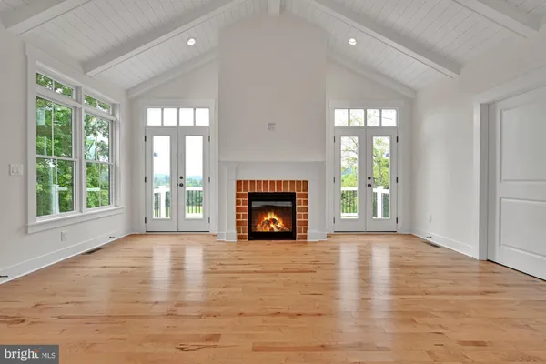 a view of an empty room with window and fire place