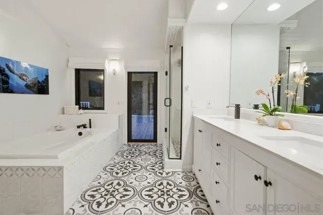 a bathroom with a double vanity sink mirror and shower