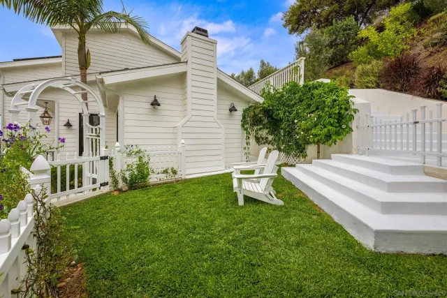 a view of a house with backyard and sitting area