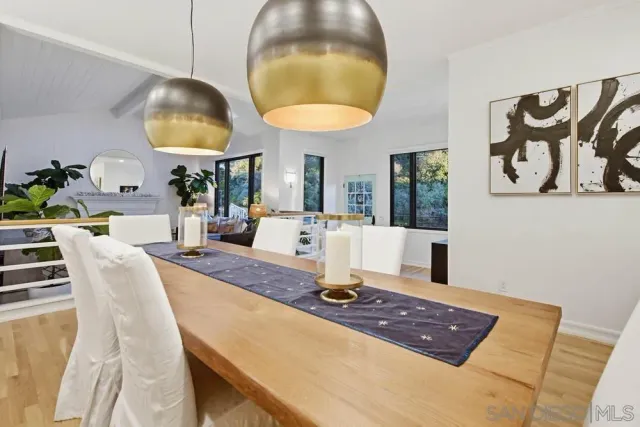 a living room with dining table and a chandelier