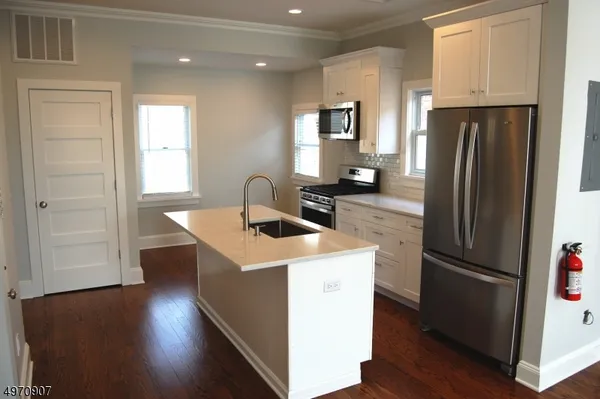 a kitchen with a refrigerator sink and cabinets