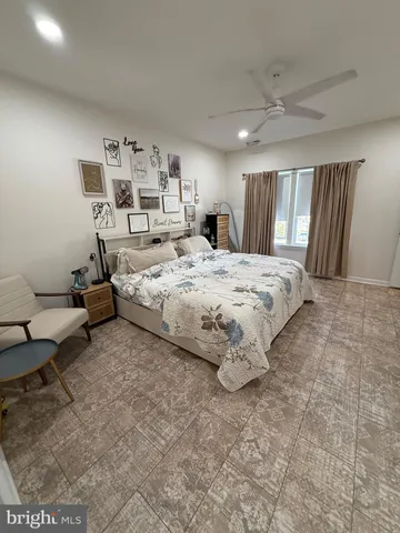 a spacious bedroom with a bed a couch and large window