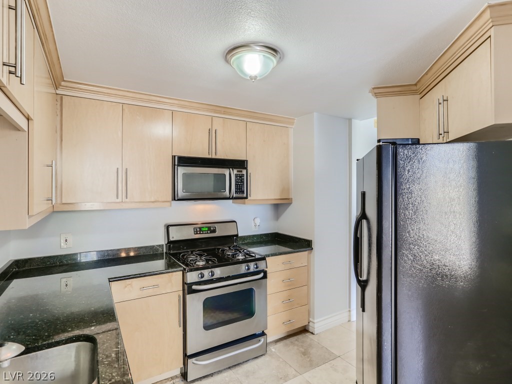 260 East Flamingo Road, Unit 220 Las Vegas, NV 89169 - Photo 9 of 32 A compact kitchen with sleek appliances and practical dark counters.