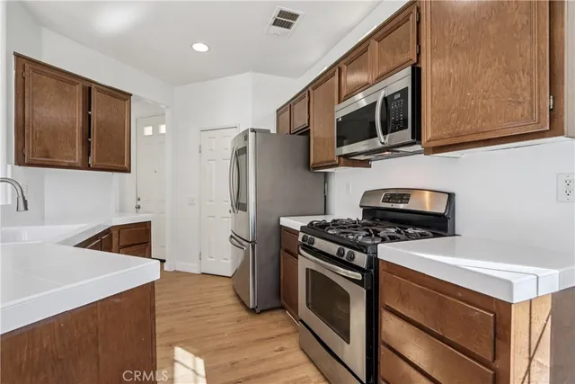 a kitchen with stainless steel appliances granite countertop a refrigerator stove and sink
