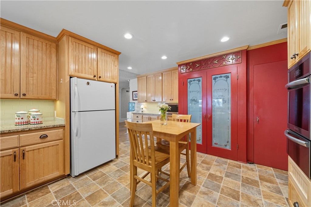 1181 Gearald Way Fallbrook, CA 92028 - Photo 17 of 39 a kitchen with refrigerator cabinets dining table and chairs