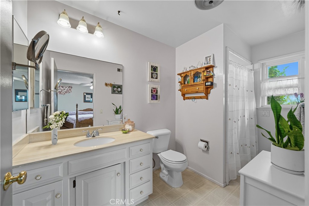1181 Gearald Way Fallbrook, CA 92028 - Photo 23 of 39 a bathroom with a toilet a sink and mirror