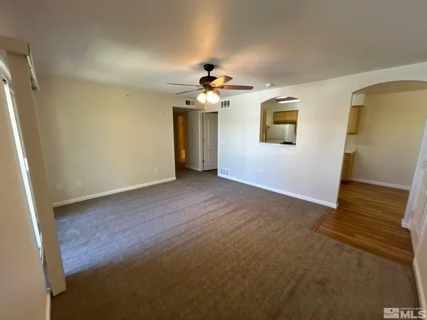a view of a room with a ceiling fan and a hardwood floor