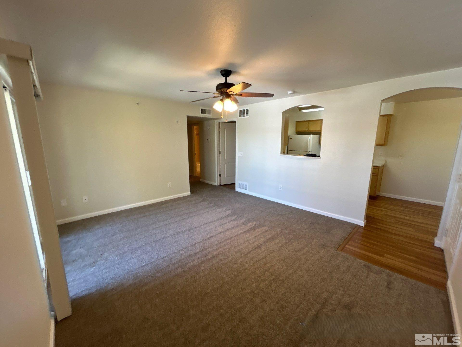 a view of a room with a ceiling fan and a hardwood floor