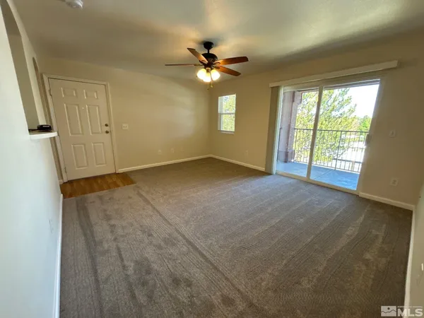 an empty room with windows and ceiling fan