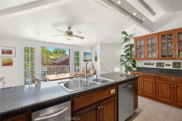 a kitchen with stainless steel appliances granite countertop a stove a refrigerator a kitchen island a table and chairs with a living room