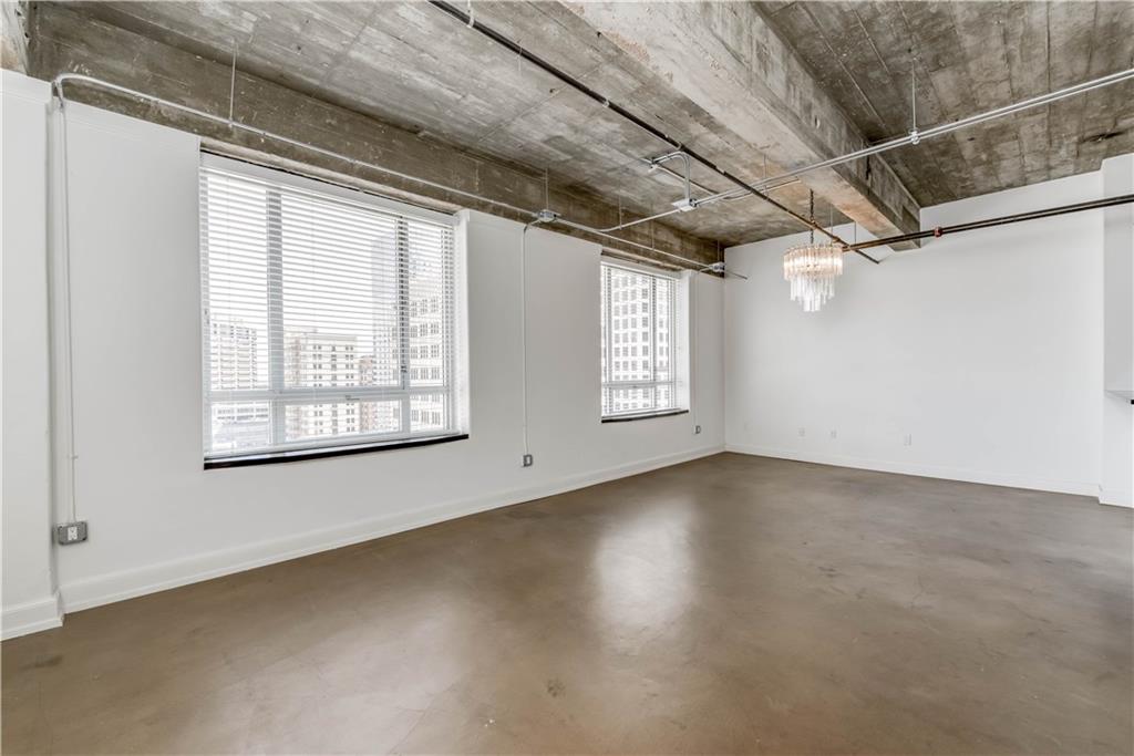 710 Colorado Street, Unit G9 Austin, TX 78701 - Photo 14 of 25 Concrete floors and exposed ductwork enhance this urban-inspired open living space.
