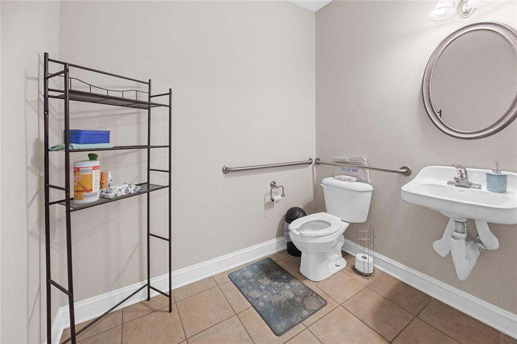 3440 Blue Springs Road, Unit 103 Kennesaw, GA 30144 - Photo 10 of 12 a bathroom with a toilet a sink and a mirror