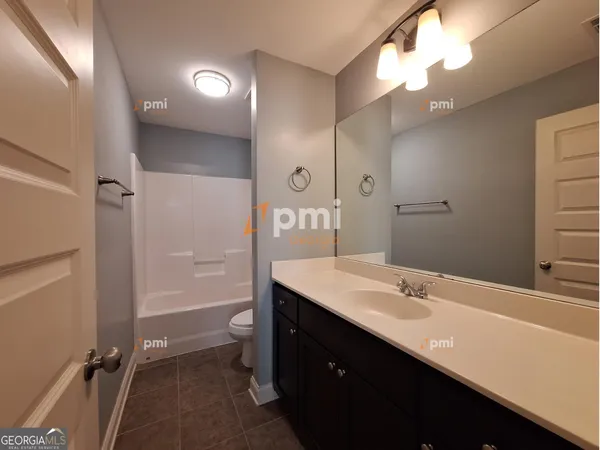 a bathroom with a sink a toilet a mirror and shower