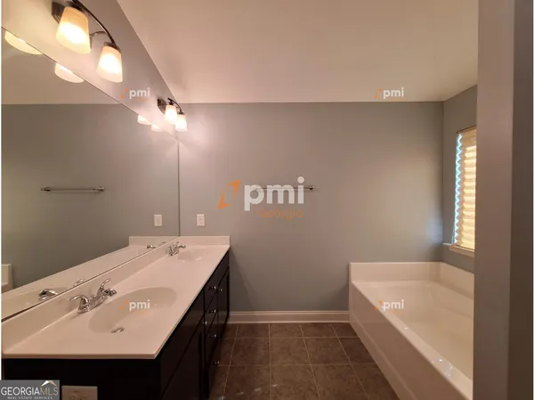 a bathroom with a sink a large mirror and a bathtub