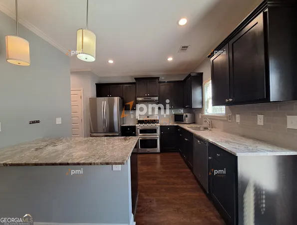 a large kitchen with stainless steel appliances kitchen island granite countertop a large island in the center