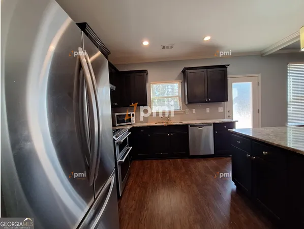 a kitchen with stainless steel appliances granite countertop a refrigerator a sink a stove a microwave and wooden cabinets