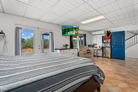 a bedroom with furniture and a large window
