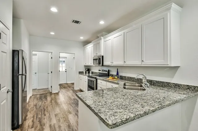 a kitchen with stainless steel appliances granite countertop a sink stove and refrigerator