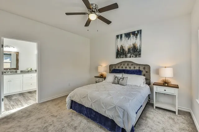 a bedroom with a large bed and a chandelier fan