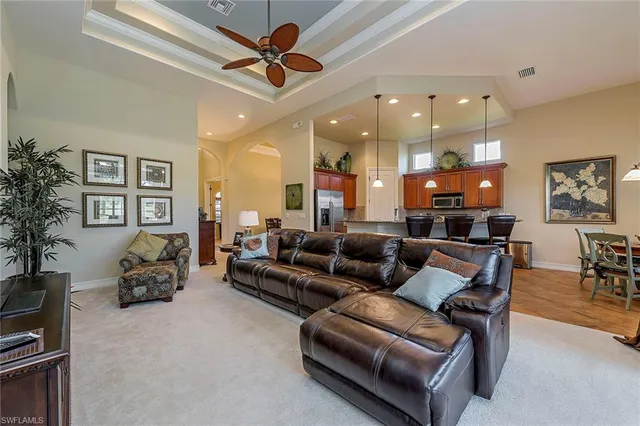 a living room with furniture and a ceiling fan