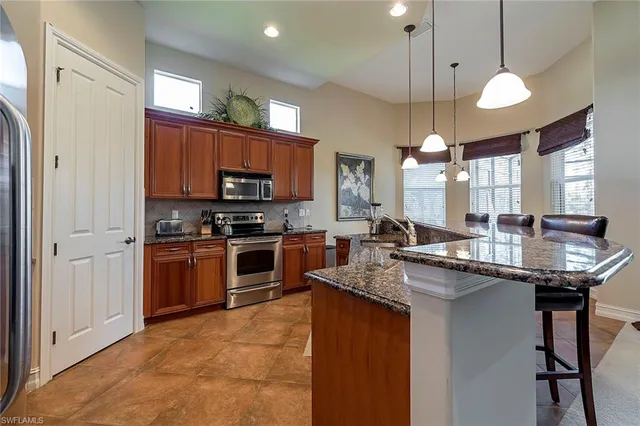 a kitchen with stainless steel appliances granite countertop a sink a stove and a refrigerator