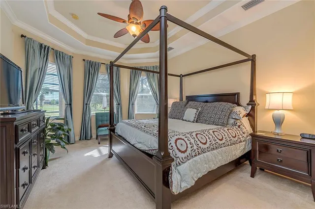 a bedroom with a bed flat screen tv and a large window